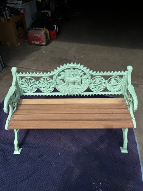 Cast-iron park bench after powder coating in mint green with new wood slats